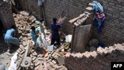 Earthquake survivors remove their belongings from the rubble of a damaged house in southern Pakistan (file photo).