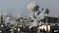 A video grab shows smoke billowing from a building in the Jouret Sheikh neighborhood of the restive central city of Homs on July 1.