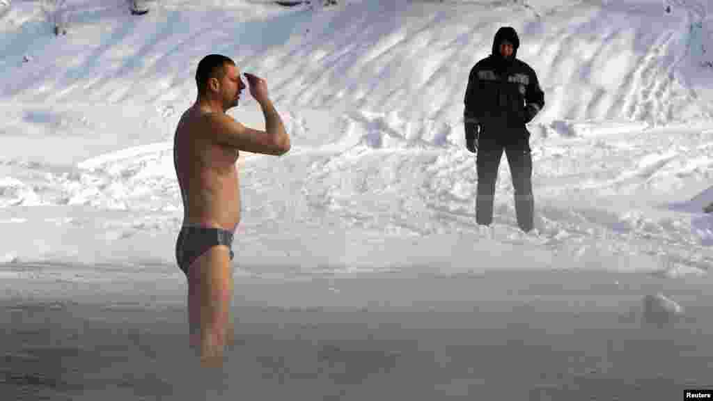 A man crosses himself after taking a dip in the icy water of the Bolshaya Almatinka river during Epiphany celebrations in Almaty, Kazakhstan, on January 19. (REUTERS/Shamil Zhumatov)