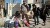 Iraqis who fled violence in Fallujah collect aid supplies in Karbala on January 9.