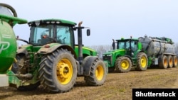 Тракторы John Deere во время полевых работ возле села Калуш, Украина, 8 апреля 2016 года