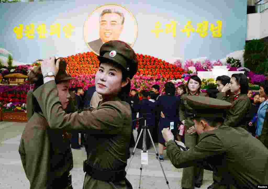 North Korean female soldiers prepare to take a commemorative photograph in front of a flower exhibition featuring North Korea&#39;s late founder Kim Il Sung in Pyongyang. (Reuters/Kyodo)