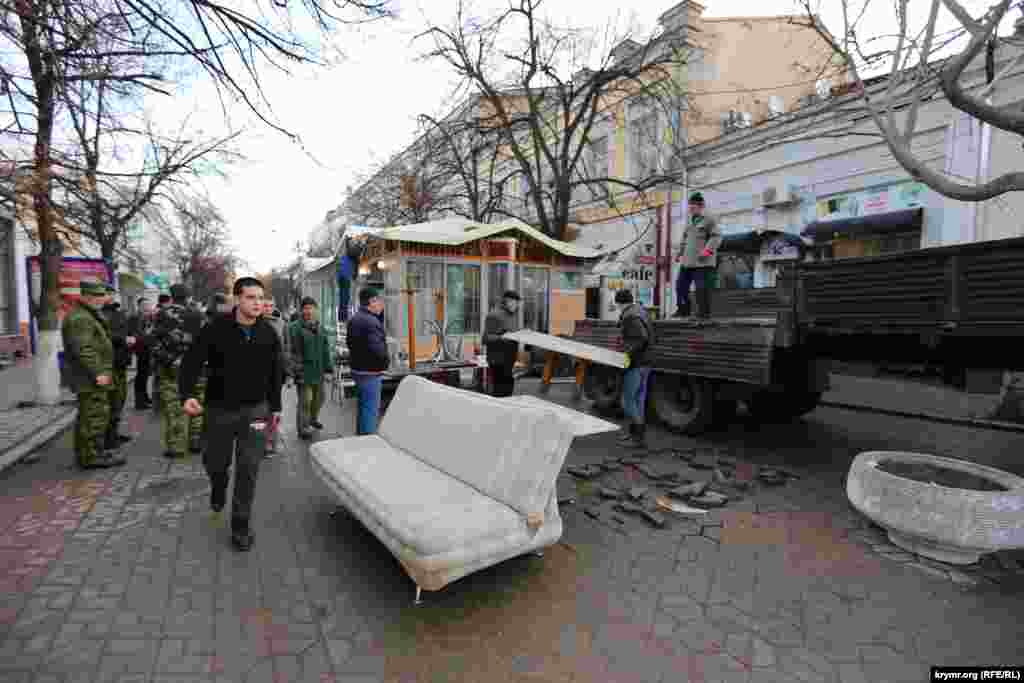 Сотрудники кафе выносят вещи и складывают их в грузовик, от комментариев отказываются. 