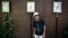 FILE: 10-year-old Farhad Nouri from Afghanistan poses in front of his drawings during his first exhibition in Belgrade in August.