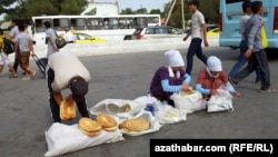 Illýustrasiýa suraty. Teke bazaryň gapdalynda çörek satýan adamlar. 