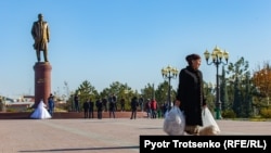 Өзбекстанның экс-президенті Ислам Каримов ескерткішінің жанынан өтіп бара жатқан тұрғын.