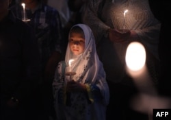 A young Muslim girl holds a candle during a vigil at the Islamic Center of Southern California in Los Angeles on February 12 for the three Muslim students who were fatally shot in North Carolina.