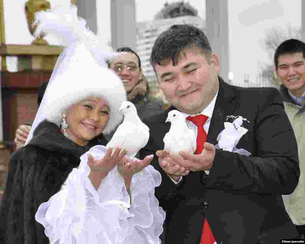 A newly married couple prepares to release a pair of doves, which is seen as a symbol of a happy life.