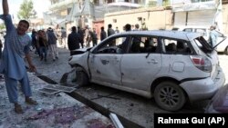 People gather outside a voter registration center that was attacked by a suicide bomber in Kabul on April 22.