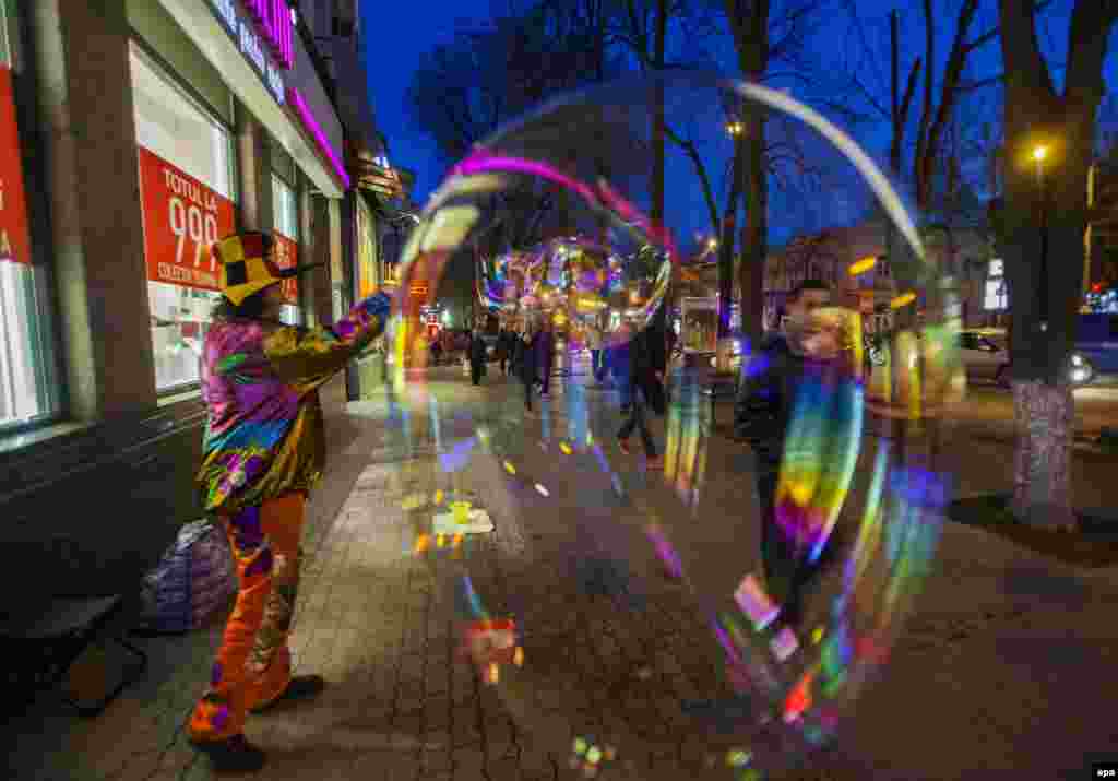 A man dressed as a clown makes huge soap bubbles in downtown Chisinau as part of the Martisor festival, which celebrates the start of spring on March 1. (epa/Dumitru Doru)