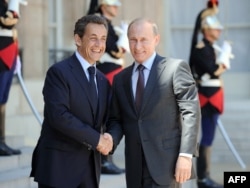 French President Nicolas Sarkozy (left) welcomes Putin at the Elysee Palace in Paris on June 11, 2010.