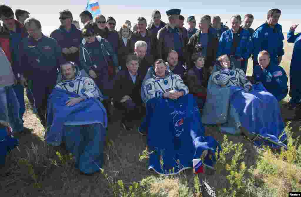 U.S. astronaut Tom Marshburn (right), Russian cosmonaut Roman Romanenko (center), and Canadian astronaut Chris Hadfield rest after leaving the Russian Soyuz space capsule following its landing in central Kazakhstan on May 14.