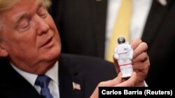 U.S. President Donald Trump holds an astronaut toy as he participates in a signing ceremony for a Space Policy Directive at the White House on December 11.