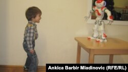 Аутизммен ауыратын хорватиялық төрт жасар Лука досымен - Рене есімді роботпен сөйлесіп тұр. Загреб, 13 қаңтар 2014 жыл. (Көрнекі сурет)