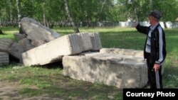 Житель села Боровое показывает бетонные плиты, выгруженные в березовой роще. Акмолинская область, 25 мая 2012 года. 