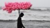 An Indian candy vendor walks along a closed beach in Puri in the eastern Indian state of Odisha as cyclone Fani approached the Indian coastline. Nearly 800,000 people in eastern India were evacuated ahead of a major cyclone packing winds gusting up to 200 kilometers per hour and torrential rains. (AFP/Dibyangshu Sarkar)