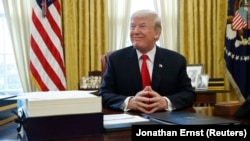 U.S. President Donald Trump sits at his desk before signing tax overhaul legislation in the Oval Office of the White House in Washington on 22, 2017.