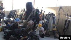A paramilitary soldier displays weapons recovered during a raid on the Muttahida Qaumi Movement (MQM) political party's headquarters in Karachi on March 11.
