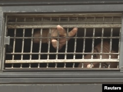 A Palestinian prisoner gestures from the window of a bus as it leaves Nafha Prison in the southern town of Mitzpe Ramon on October 16.