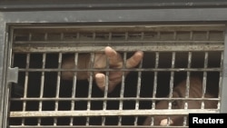 A Palestinian detainee gestures from the window of a bus as it leaves a jail ahead of a prisoner swap on October 18. 