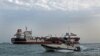 A boat of Iran's Islamic Revolutionary Guards Corps passes the Stena Impero, a British-flagged oil tanker that was seized by Iran in the Strait of Hormuz in July 2019 (file photo)