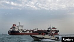 A boat of Iranian Revolutionary Guard sails next to Stena Impero, July 21, 2019