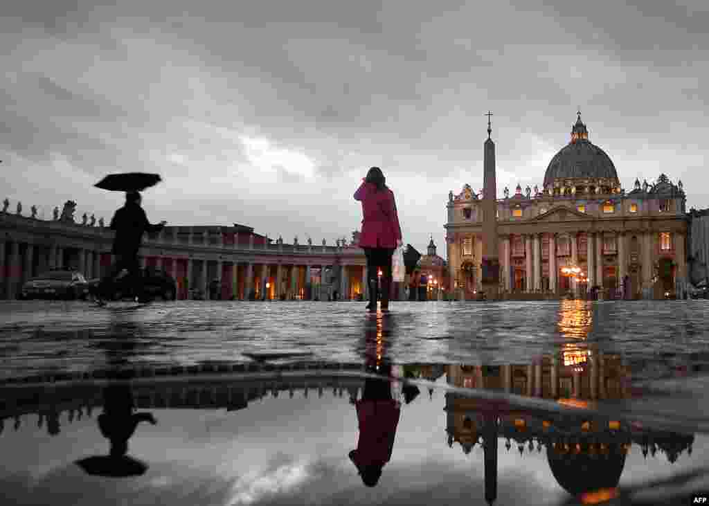 People walk in St. Peter's Square. The Vatican announced that Roman Catholic cardinals would start their conclave to elect a successor to Pope Benedict XVI on March 12. (AFP/Filippo Monteforte)