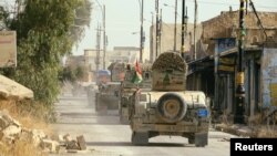 Peshmerga forces ride on military vehicles in the town of Bashiqa after it was recaptured from the Islamic State, east of Mosul, Iraq, on November 9.