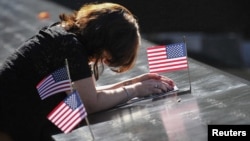 أميركية تنحني أمام إسم زوجها المنقوش في نصب لتخليد ضحايا هجمات 11 أيلول في نيويورك
