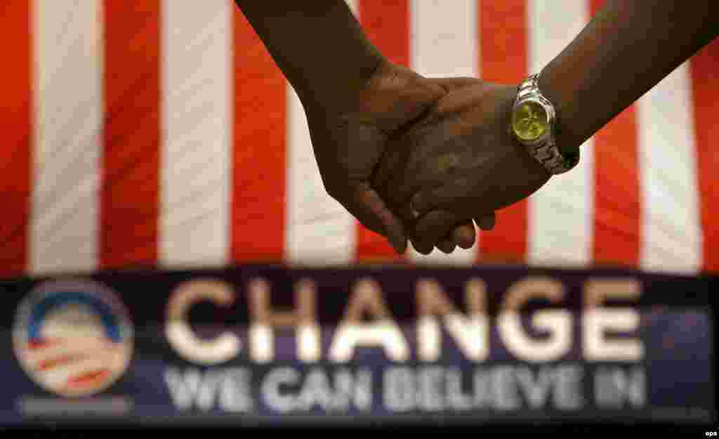 America embraces change. - Supporters stand and hold hands during a prayer while waiting on Democratic presidential hopeful US Senator Barack Obama to arrive and speak at a rally at the Verizon Wireless Amphitheater in Selma, Texas, USA, 29 February 2008. The Texas Primary is 04 March 2008. 