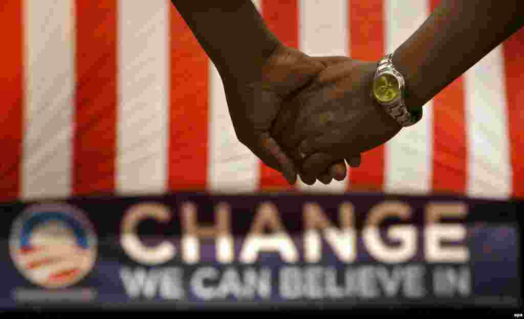 America embraces change. - Supporters stand and hold hands during a prayer while waiting on Democratic presidential hopeful US Senator Barack Obama to arrive and speak at a rally at the Verizon Wireless Amphitheater in Selma, Texas, USA, 29 February 2008. The Texas Primary is 04 March 2008.