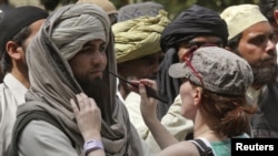 A crew member of Oscar-winning director Kathryn Bigelow's team for the movie "Zero Dark Thirty" applies makeup on an actor during a shoot at the filming location in the northern Indian city of Chandigarh.