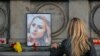 Žena ostavlja cvijet ispred portreta ubijene bugarske novinarke Viktorije Marinove tokom skupa na kojem joj je odata počast u gardu Ruse 8. oktobra 2018.