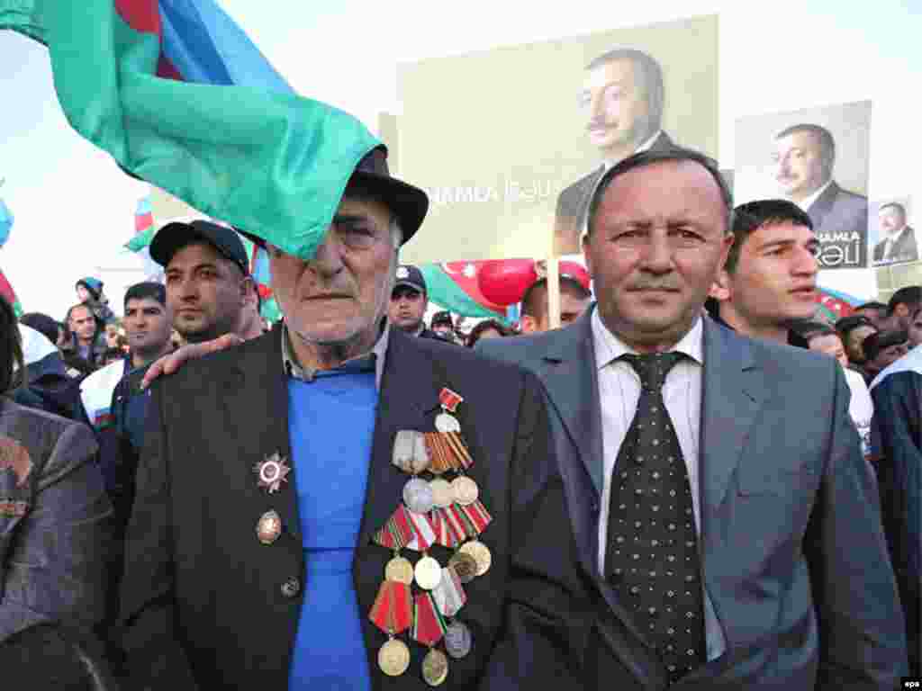 Caption: epa01519140 Azeri people stand in front of pre-electoral posters of candidate and present President of Azerbaidan Ilkham Aliyev during a rally supporting his candidacy in the upcoming presidential elections in Sumgait, some 30km from Baku, Azerbaijan, 13 October 2008.