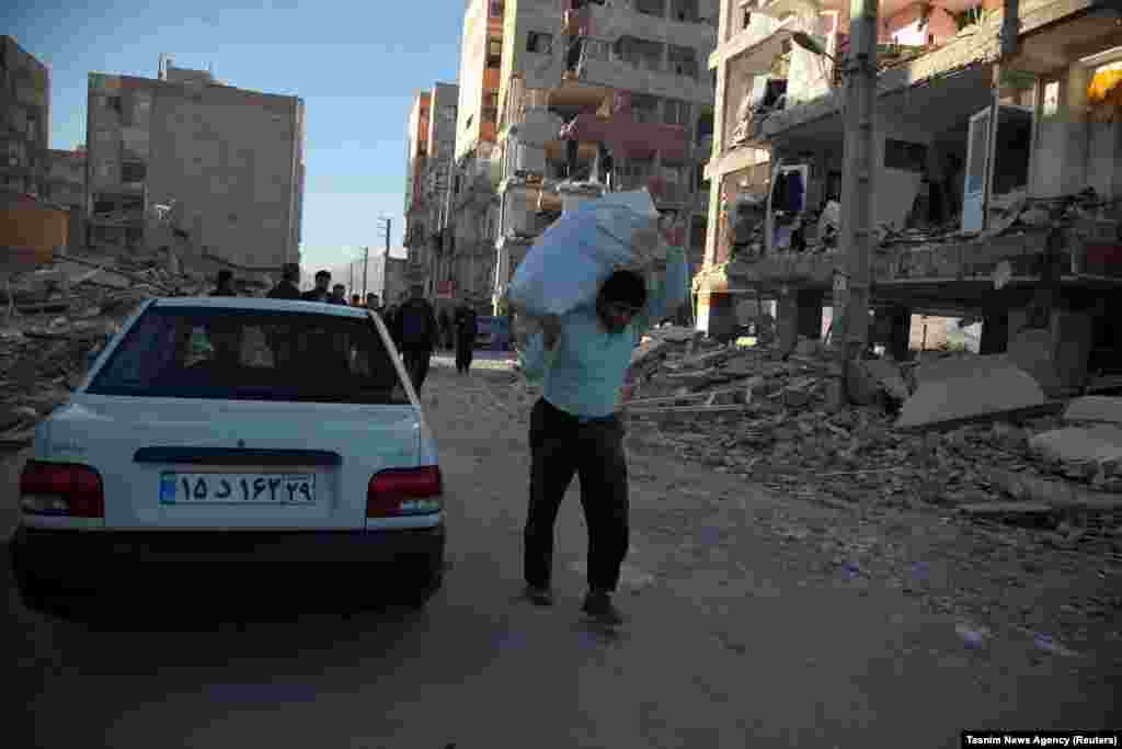A man carries his belongings following an earthquake in Sarpol-e Zahab county in Kermanshah.
