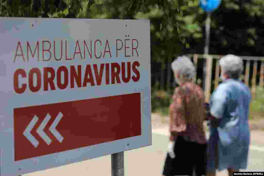Dy qytetare duke ecur pranë Klinikës Infektive në Prishtinë.