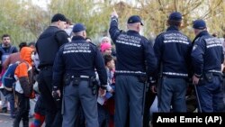 Bosnian police officers prevent migrants from crossing the border at Izacic on the border with Croatia on October 23.