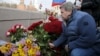 A man lays flowers on the bridge in Moscow where Russian politician Boris Nemtsov was killed.