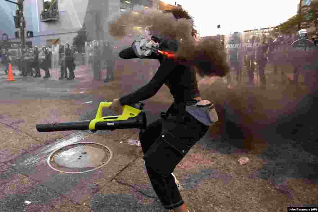 Протестувальник кидає димову шашку в поліцейських, Атланта