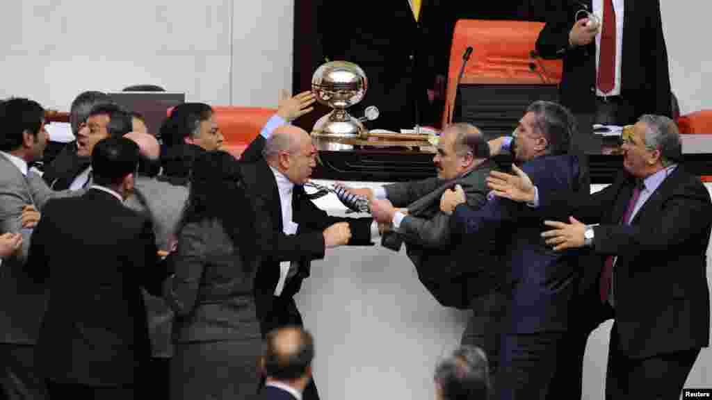 A ruling AKP lawmaker, Muhittin Aksak (right), and Mahmut Tanal, a deputy with main opposition Republican People's Party, scuffle during a debate in the Turkish parliament in Ankara on February 8. (REUTERS)