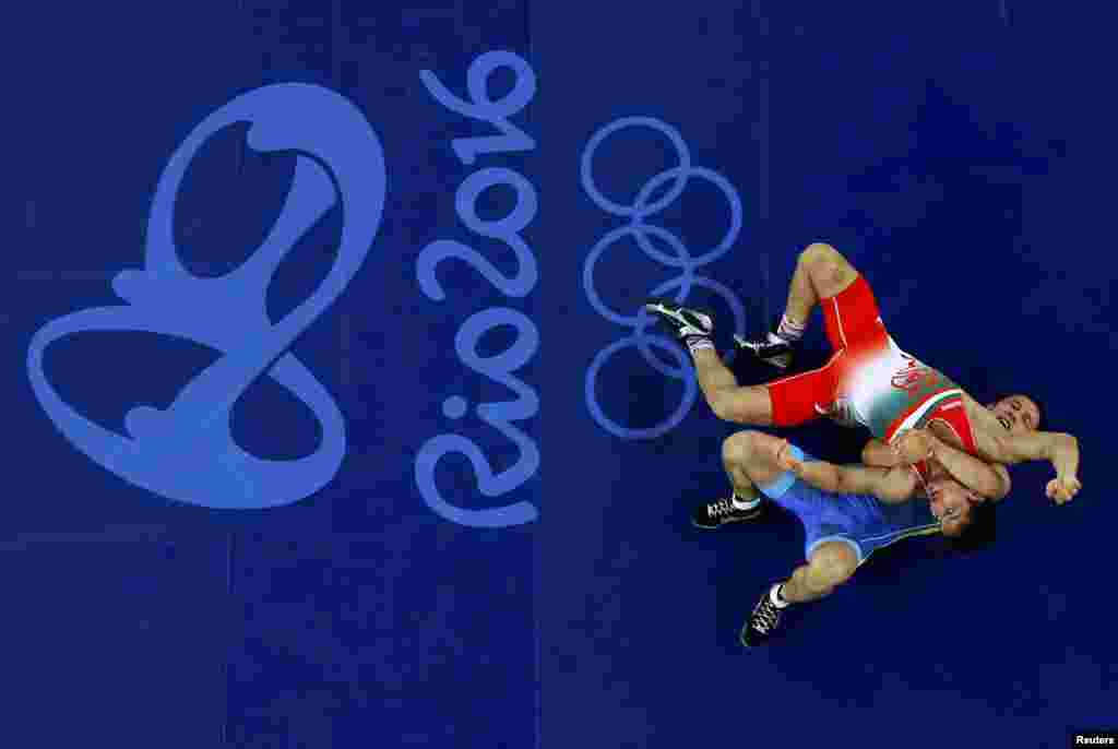 Hamid Mohammad Soryan of Iran and Almat Kebispayev of Kazakhstan compete in Greco-Roman wrestling in the 59-kilogram weight class. 