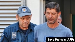 Vlado Zmajevic (right) is escorted by a police offier after being arrested in Niksic in August 2016.