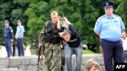 Бойовик угруповання «ДНР» затримує чоловіка, підозрюваного у шпигунстві для України, Донецьк, 21 червня 2014 року