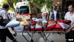 Medics carry a wounded Ukrainian soldier to an ambulance at a military hospital in Kyiv before being transported to Germany on September 2.