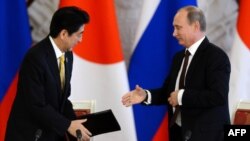 Vladimir Putin (sağda) və Shinzo Abe, arxiv fotosu