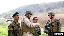 Afghan Army officers discuss lessons learned alongside Marines and Navy personnel while participating in combat-scenario training exercises.