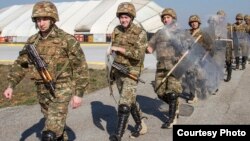 Kosovo - Armenian soldiers walk in riot gear to a UH-60 Black Hawk during a training exercise on Camp Bondsteel, Kosovo, March 12, 2014. (Photo courtesy of www.army.mil)