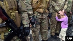 Дитина біля свого батька – бійця добровольчого батальйону «Січ» у день присяги і відправлення підрозділу в зону бойових дій, Київ, 26 серпня 2014 року