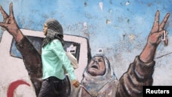 Palestine - A Palestinian woman walks past an anti-Israel mural in Gaza City, 02Sep2010