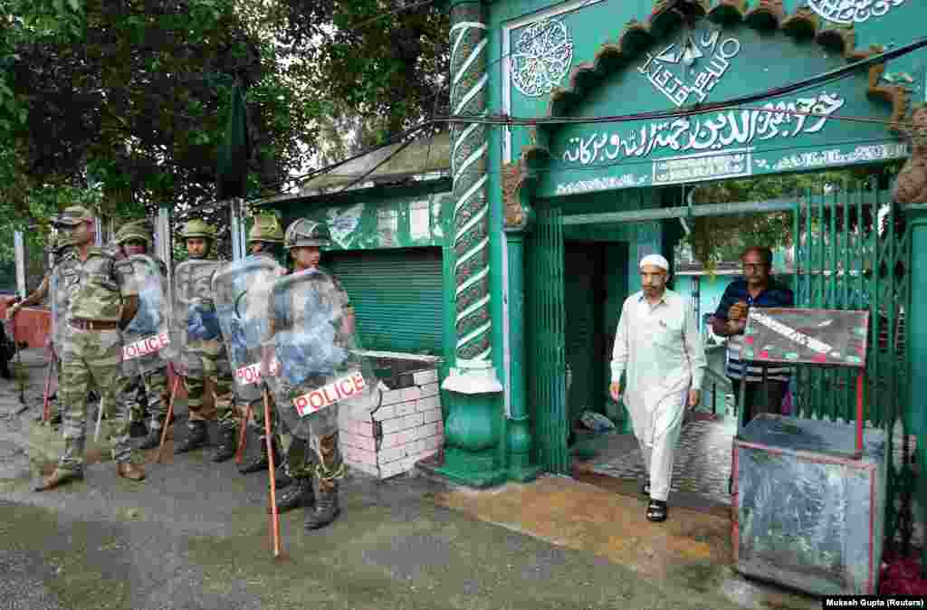 A Muslim man leaves a mosque after offering Friday prayers as Indian security force personnel stand guard during restrictions following the scrapping of the special constitutional status for Kashmir by the Indian government, in Jammu on August 9.